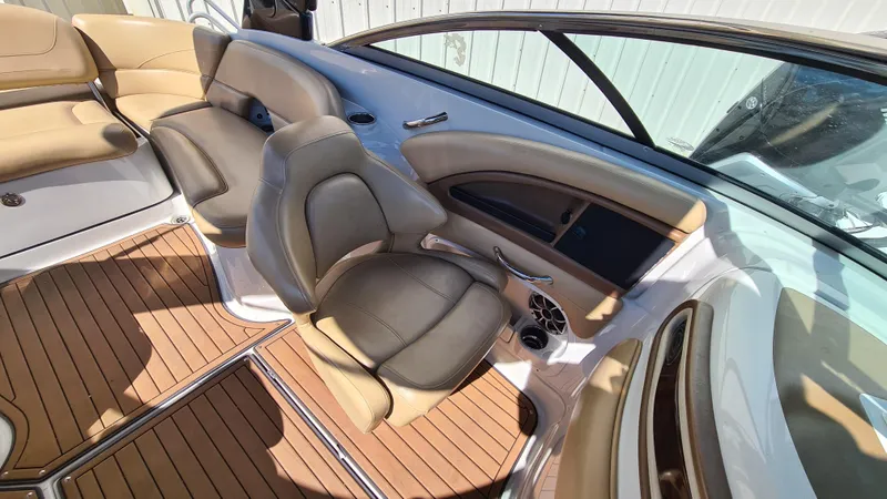 Slide: The Image of 2018 Crownline Eclipse E24 XS boat interior with tan seating and wood-style flooring. - 11