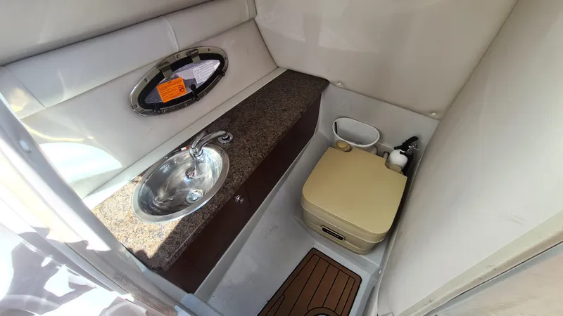 Slide: The Image of 2018 Crownline Eclipse E24 XS boat bathroom with sink and portable toilet. - 12