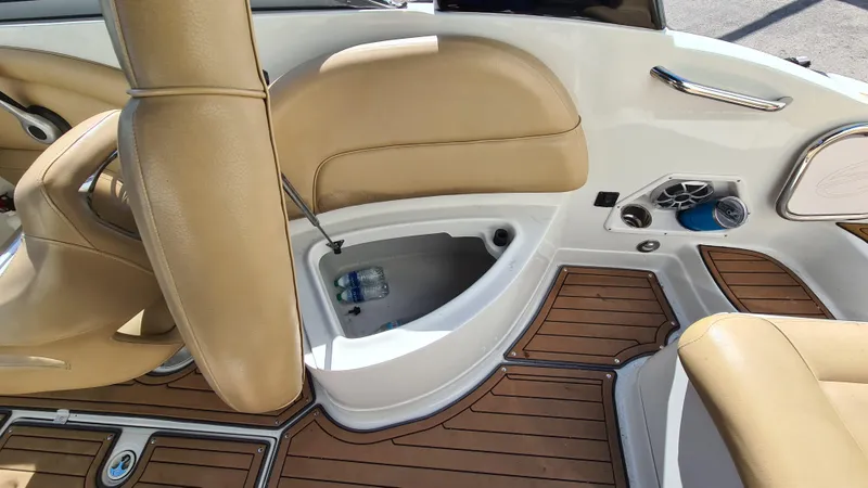 Slide: The Image of 2018 Crownline Eclipse E24 XS boat interior with tan seating and wood-style flooring. - 13