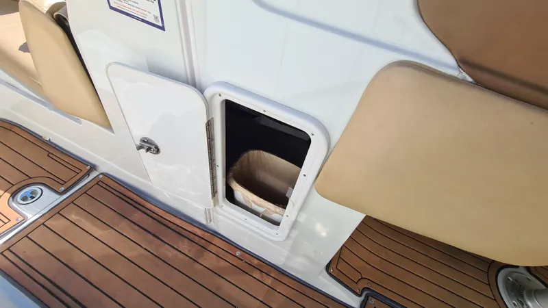 Slide: The Image of 2018 Crownline Eclipse E24 XS boat with open storage compartment and teak flooring. - 15