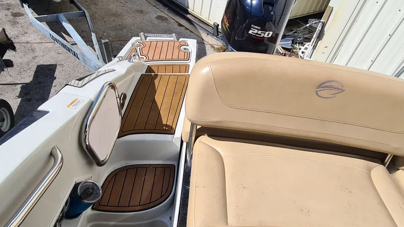 Slide: The Image of 2018 Crownline Eclipse E24 XS boat interior with tan seating and teak flooring. - 18