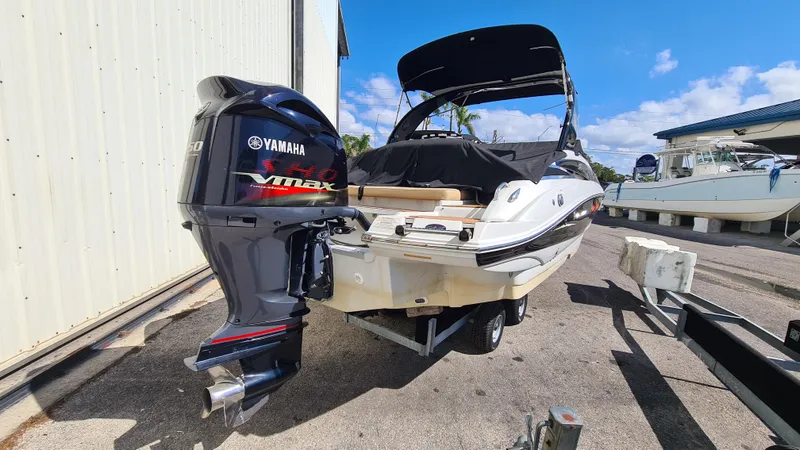 Slide: The Image of 2018 Crownline Eclipse E24 XS boat with Yamaha VMAX outboard motor, parked outdoors. - 2