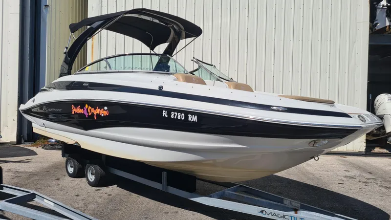 Slide: The Image of 2018 Crownline Eclipse E24 XS boat on trailer, black and white design, docked outdoors. - 3