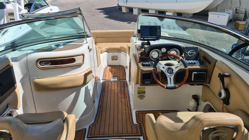 Slide: The Image of 2018 Crownline Eclipse E24 XS boat interior with tan seating and wood accents. - 8