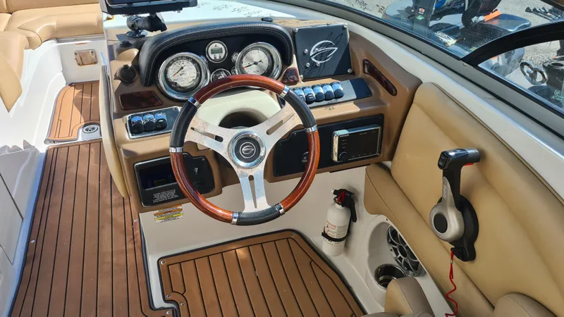 Slide: The Image of 2018 Crownline Eclipse E24 XS boat dashboard with wood accents and steering wheel. - 9