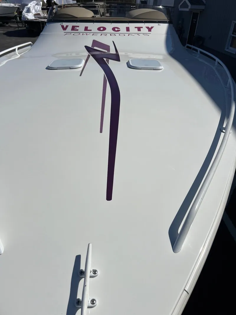 Slide: The Image of 1998 Velocity 260 boat with sleek design and purple graphics. - 13
