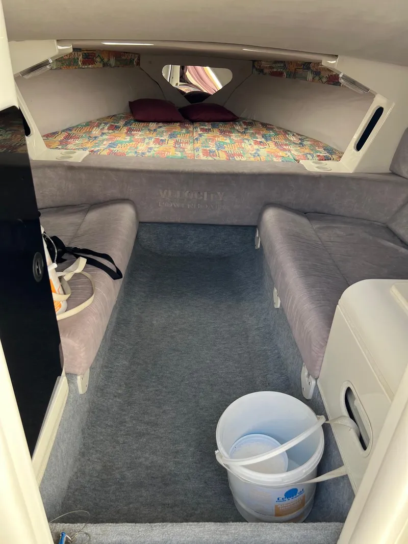 Slide: The Image of Interior of a 1998 Velocity 260 boat cabin with seating and a bucket. - 14
