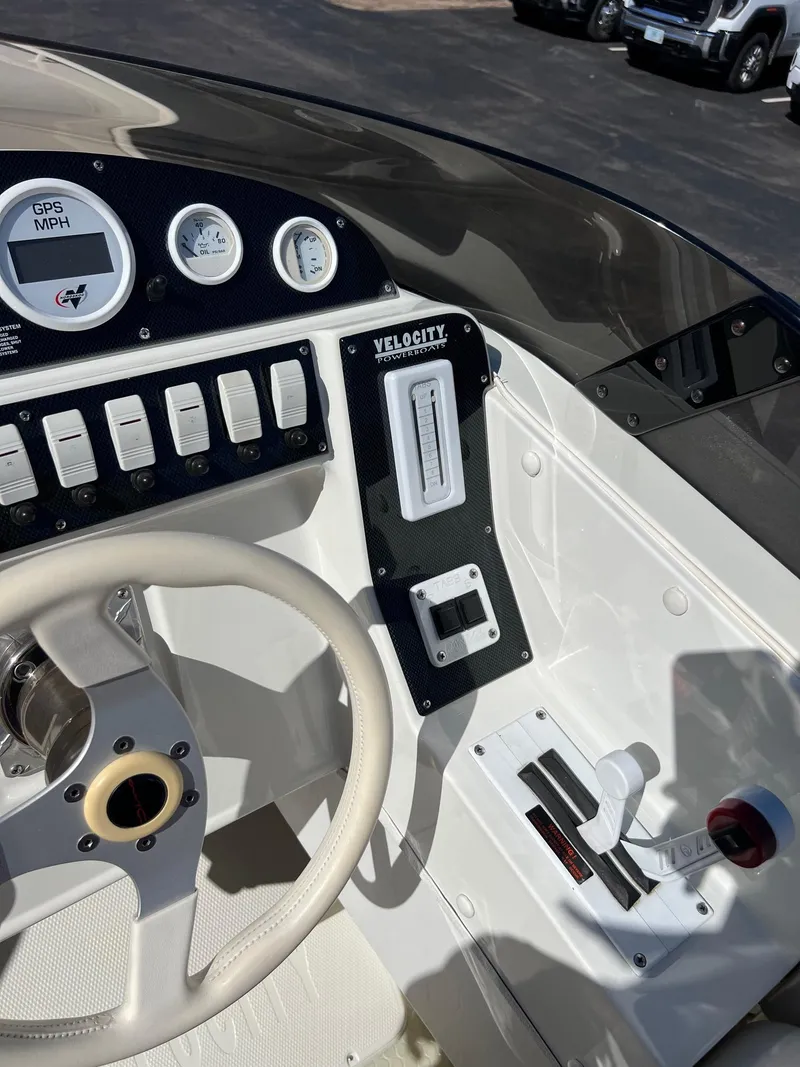 Slide: The Image of 1998 Velocity 260 boat dashboard with steering wheel and control panel. - 17