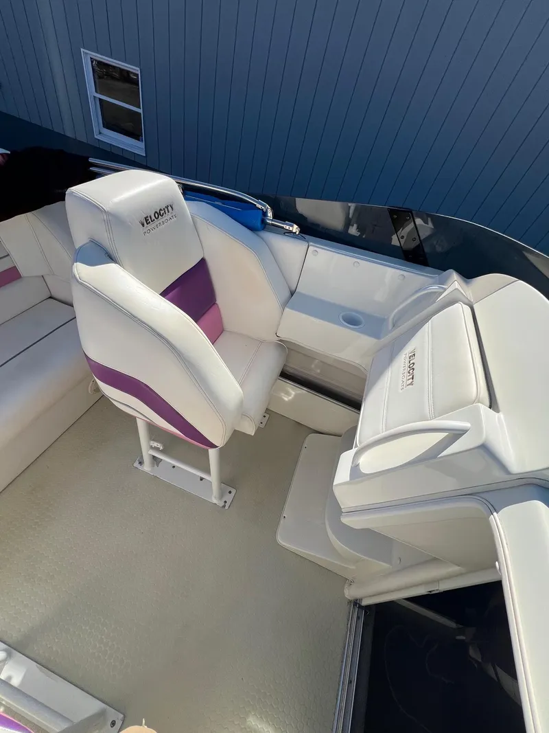 Slide: The Image of 1998 Velocity 260 boat interior with white and purple seating. - 19