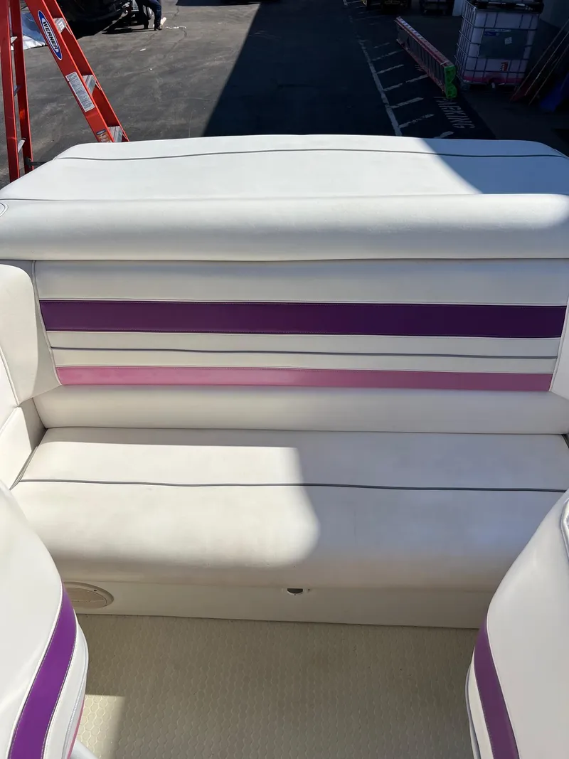 Slide: The Image of 1998 Velocity 260 boat interior with white and purple seating. - 22