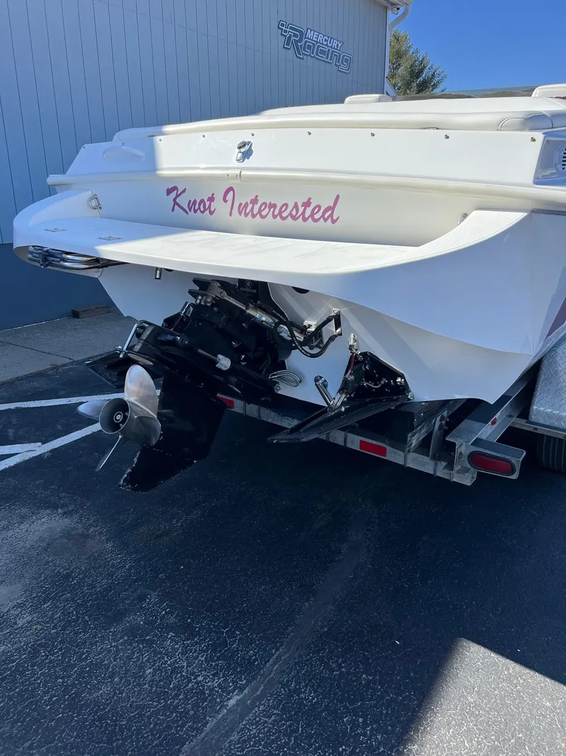 Slide: The Image of 1998 Velocity 260 boat with "Knot Interested" name, parked on a trailer. - 4