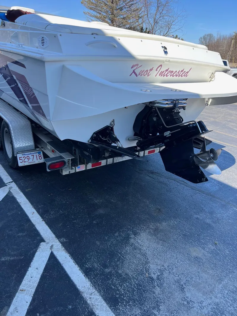 Slide: The Image of 1998 Velocity 260 boat on trailer, rear view, with "Knot Interested" text. - 5