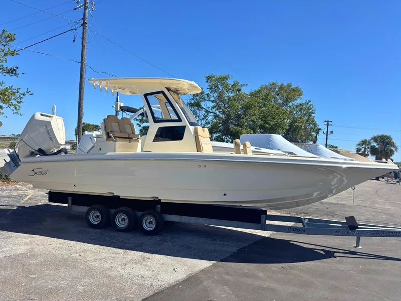 The Image of 2025 Scout 261 XSS boat on calm water under a blue sky. - 0