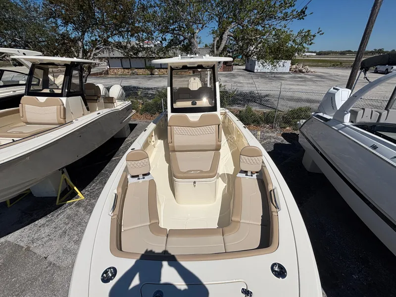 Slide: The Image of 2025 Scout 261 XSS boat with beige cushioned seating and steering wheel. - 10