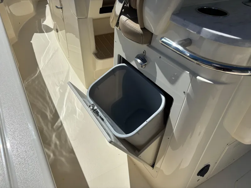 Slide: The Image of 2025 Scout 261 XSS boat with beige seating, docked outdoors. - 12