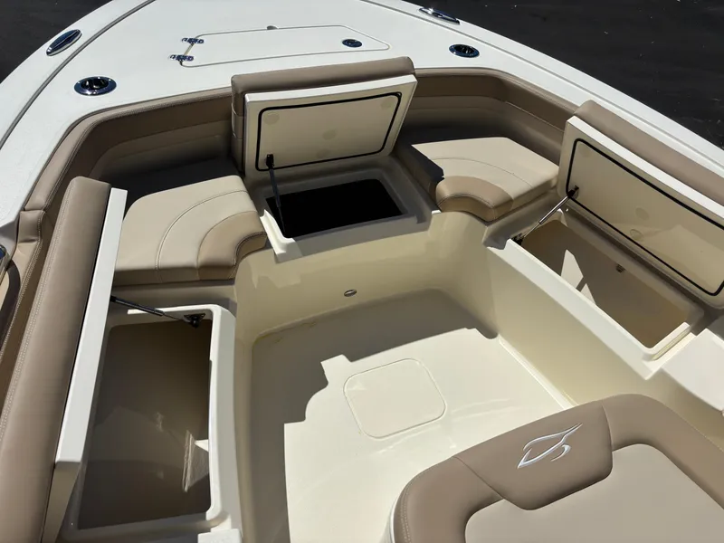 Slide: The Image of 2025 Scout 261 XSS boat interior with open storage compartment and trash bin. - 14