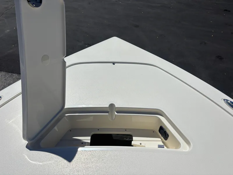 Slide: The Image of 2025 Scout 261 XSS boat interior with open storage compartments and cushioned seating. - 16