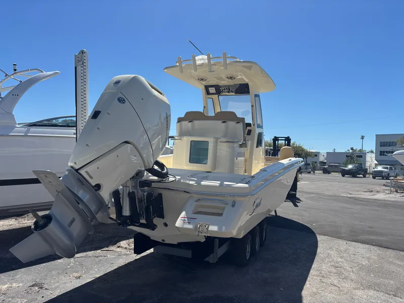 Slide: The Image of 2025 Scout 261 XSS boat on trailer, parked outdoors under clear blue sky. - 2