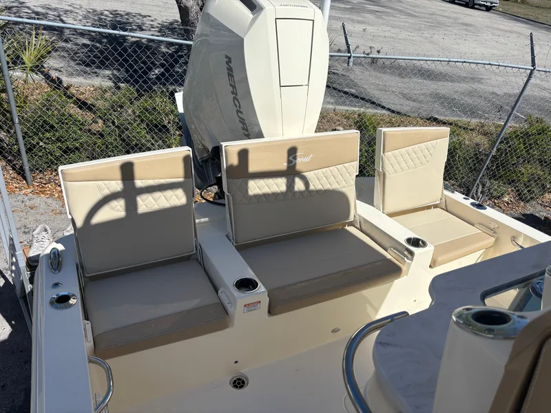 Slide: The Image of 2025 Scout 261 XSS boat with outboard motor, parked on a trailer in a marina. - 4