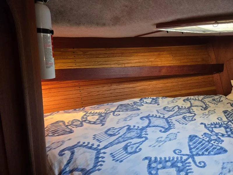 Slide: The Image of Cozy cabin interior of 1991 Freedom F-38 sailboat with patterned bedding and fire extinguisher. - 14