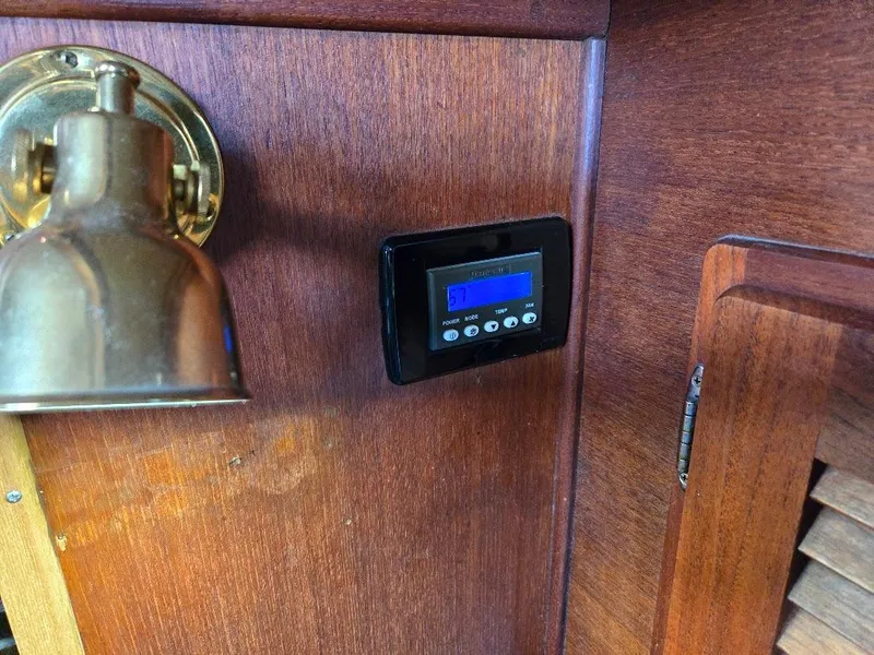 Slide: The Image of Wall-mounted digital control panel and brass lamp on wooden interior of 1991 Freedom F-38. - 24
