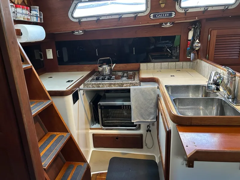 Slide: The Image of Compact boat galley with stove, sink, and microwave in a 1991 Freedom F-38. - 28