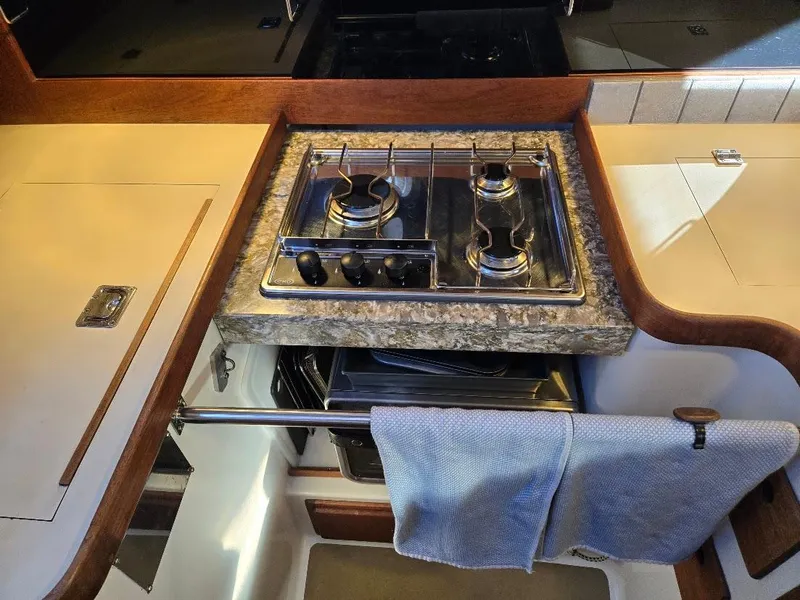 Slide: The Image of Compact kitchen area in a 1991 Freedom F-38 boat with a two-burner stove. - 32