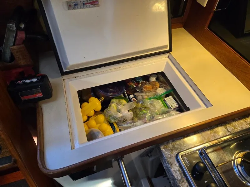 Slide: The Image of Built-in cooler with assorted items in a 1991 Freedom F-38 boat kitchen. - 35