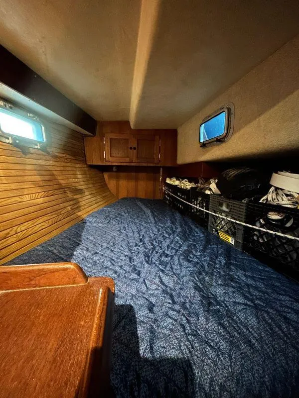 Slide: The Image of Interior cabin of 1991 Freedom F-38 sailboat with wood paneling and blue bedding. - 45