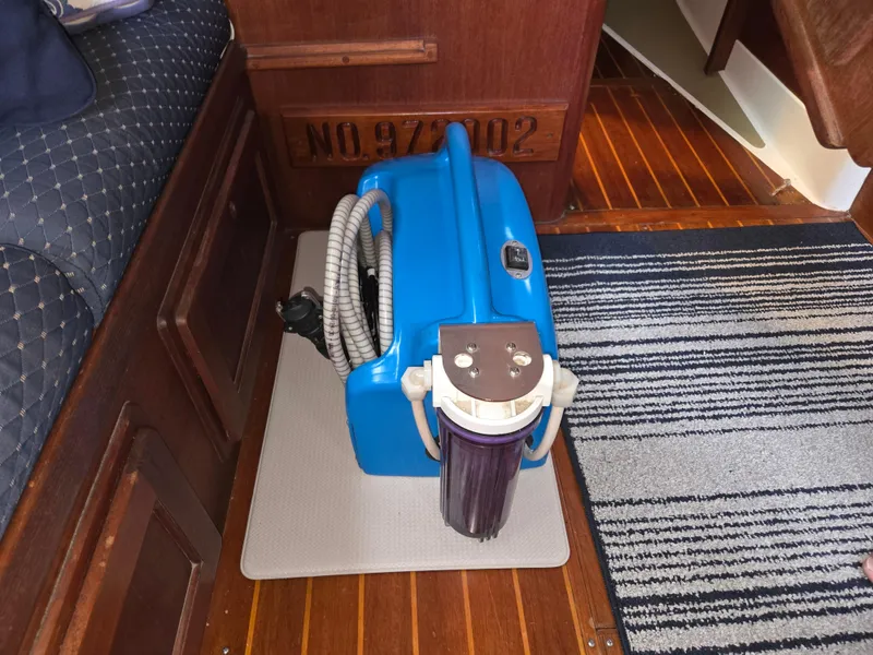 Slide: The Image of Blue vacuum cleaner on wooden floor of 1991 Freedom F-38 boat interior. - 48