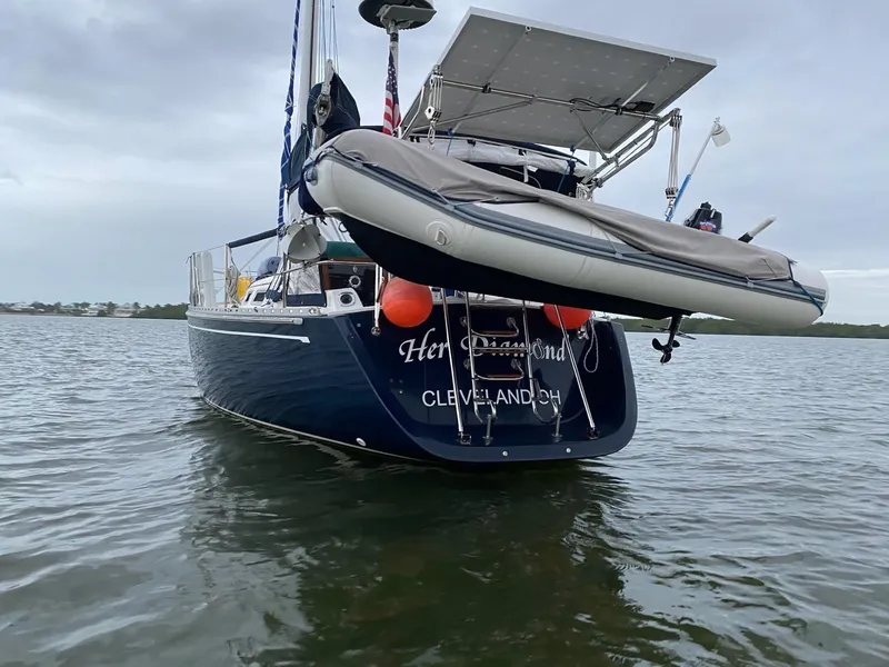 Slide: The Image of Sailboat Freedom F-38, 1991 model, with dinghy, anchored in calm waters. - 51