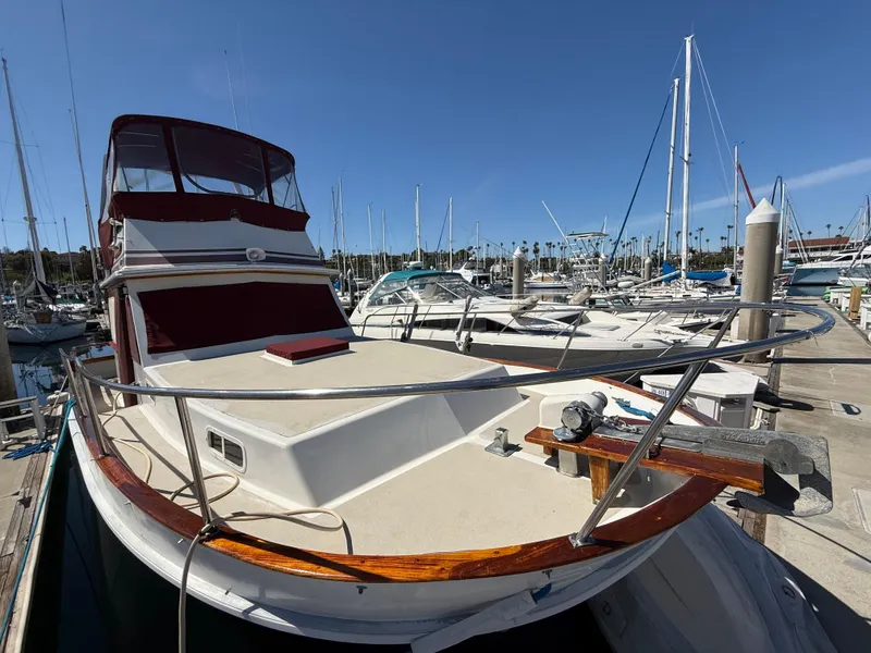Slide: The Image of 1983 Californian 34 yacht docked at marina, featuring spacious deck and classic design. - 12
