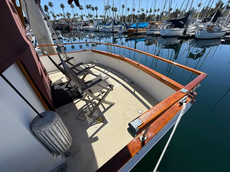 Slide: The Image of 1983 Californian 34 yacht deck with chairs, docked in a marina with sailboats. - 13