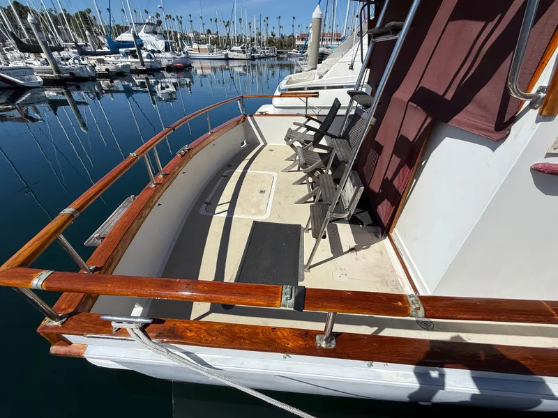 Slide: The Image of 1983 Californian 34 yacht deck with wooden railings and chairs, docked at marina. - 15