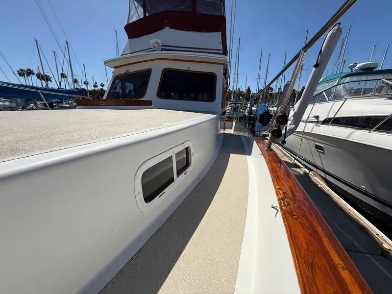 Slide: The Image of 1983 Californian 34 yacht docked, showcasing sleek design and polished wood accents. - 19