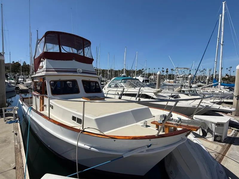 Slide: The Image of 1983 Californian 34 yacht docked at marina under clear blue sky. - 2