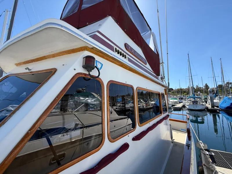 Slide: The Image of 1983 Californian 34 boat docked at marina, featuring classic design and red accents. - 20