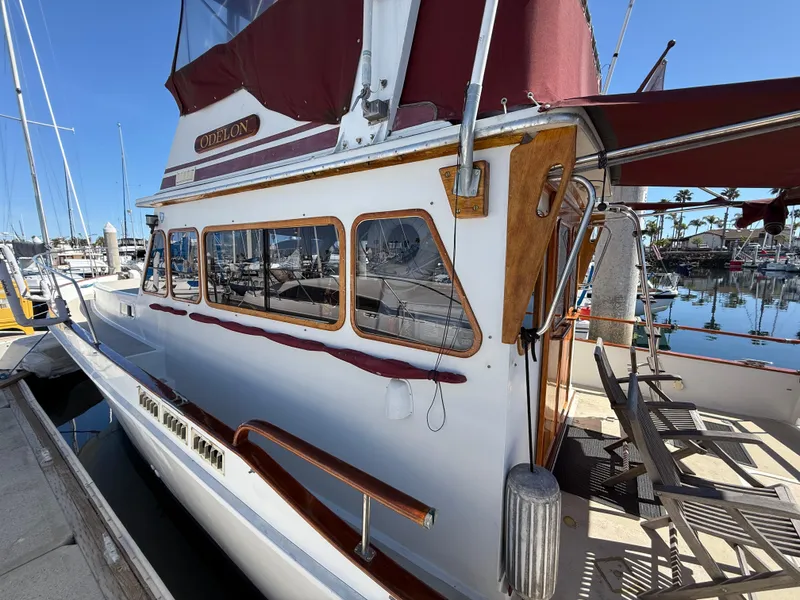 Slide: The Image of 1983 Californian 34 yacht docked at marina, featuring classic design and maroon accents. - 21