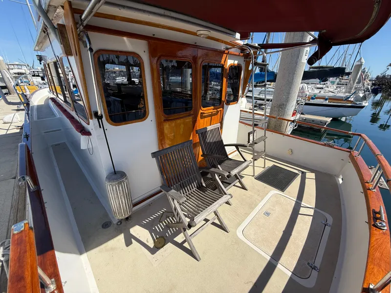 Slide: The Image of 1983 Californian 34 yacht deck with wooden chairs, docked at marina. - 23