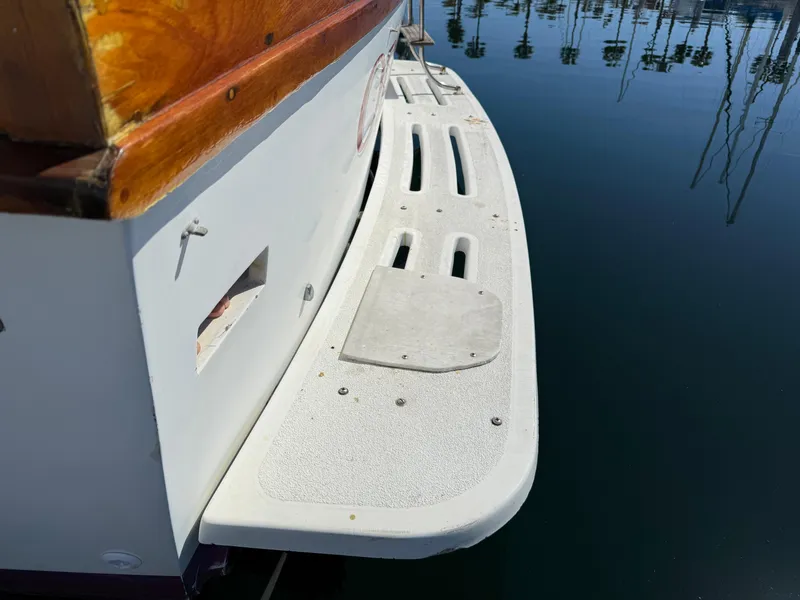 Slide: The Image of 1983 Californian 34 boat swim platform with wood trim, docked in calm water. - 24