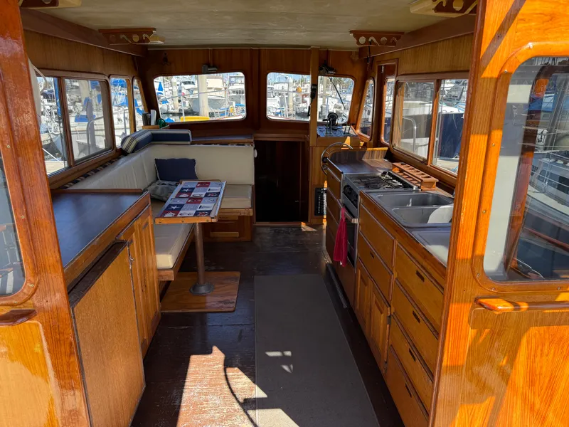 Slide: The Image of Interior of a 1983 Californian 34 boat with wooden furnishings and marina view. - 25