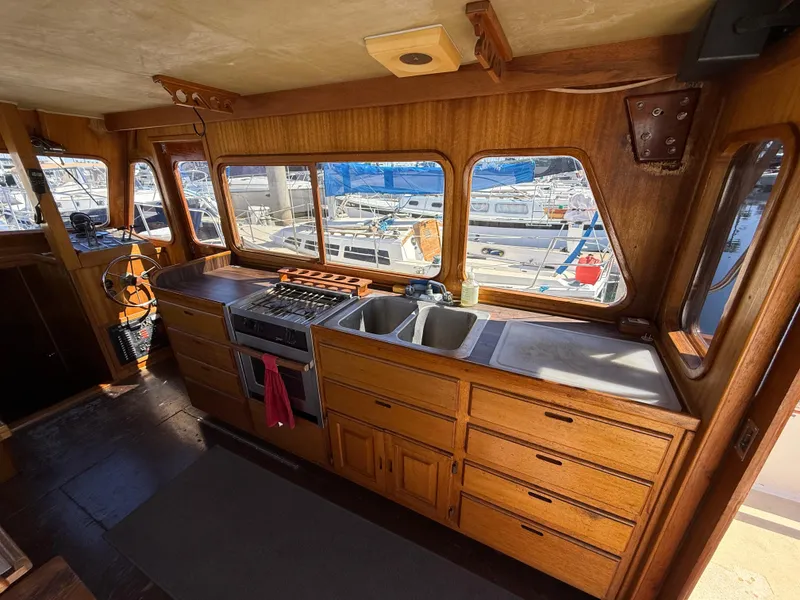Slide: The Image of 1983 Californian 34 boat interior with wooden cabinetry and marina view. - 27