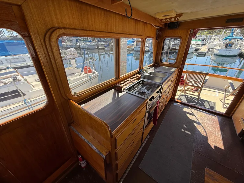 Slide: The Image of 1983 Californian 34 boat interior with wooden kitchen, marina view through windows. - 30