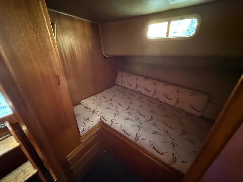 Slide: The Image of 1983 Californian 34 boat cabin with wooden interior and patterned bedding. - 39