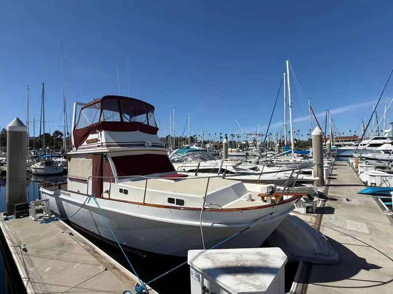 Slide: The Image of 1983 Californian 34 yacht docked at marina under clear blue sky. - 4