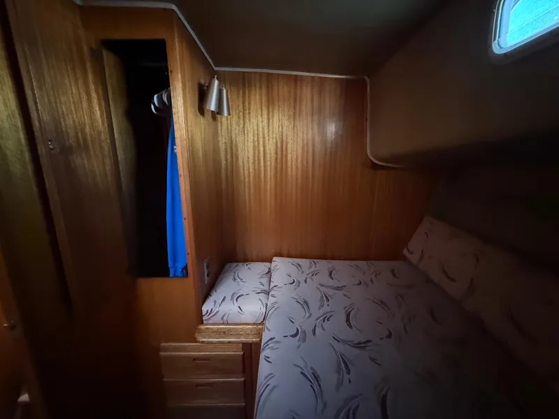 Slide: The Image of Cozy cabin interior of 1983 Californian 34 yacht with wooden paneling and patterned bedding. - 40