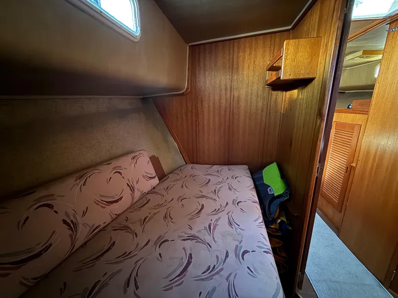 Slide: The Image of Cozy cabin interior of 1983 Californian 34 boat with patterned bedding and wooden walls. - 41