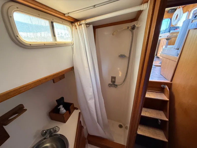 Slide: The Image of 1983 Californian 34 yacht bathroom with shower, sink, and wooden accents. - 44