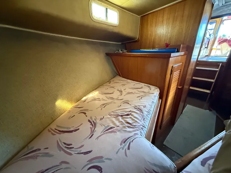Slide: The Image of 1983 Californian 34 yacht interior with cozy bed and wooden cabinetry. - 49