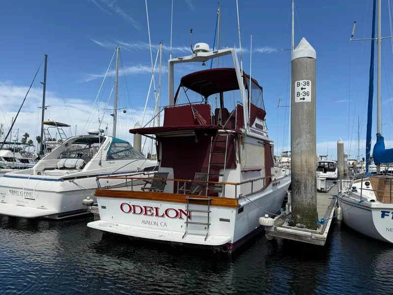 Slide: The Image of 1983 Californian 34 yacht docked at marina, featuring red accents and "ODELON" on the stern. - 7